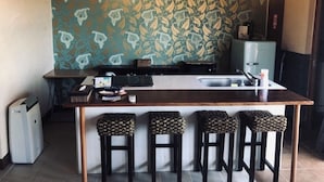 Una cocina con una isla central, taburetes de bar e iluminación colgante.