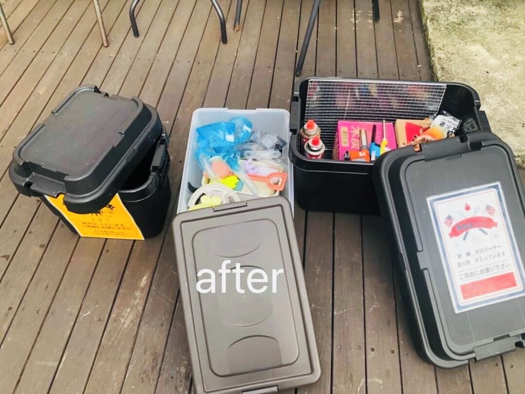 A wooden deck with three storage containers.