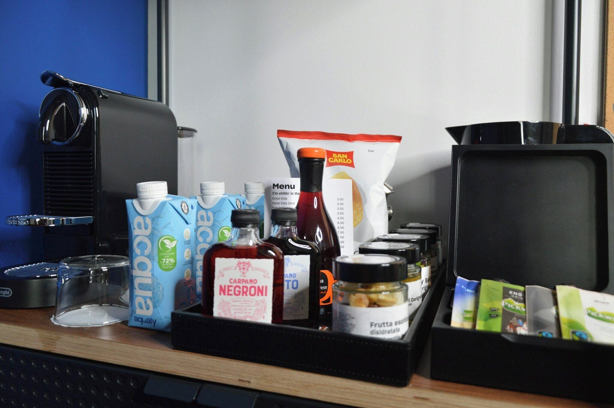 Una zona de barista amb una màquina de cafè, cartrons de llet, condiments i un menú.