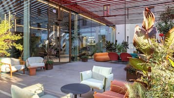 Un espace extérieur aménagé avec des meubles modernes et un mur en verre.