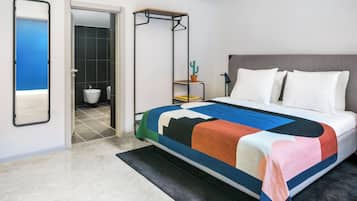 Un dormitorio con cama, mesita de noche, sillón colgante, espejo y baño visible a través de una puerta abierta.