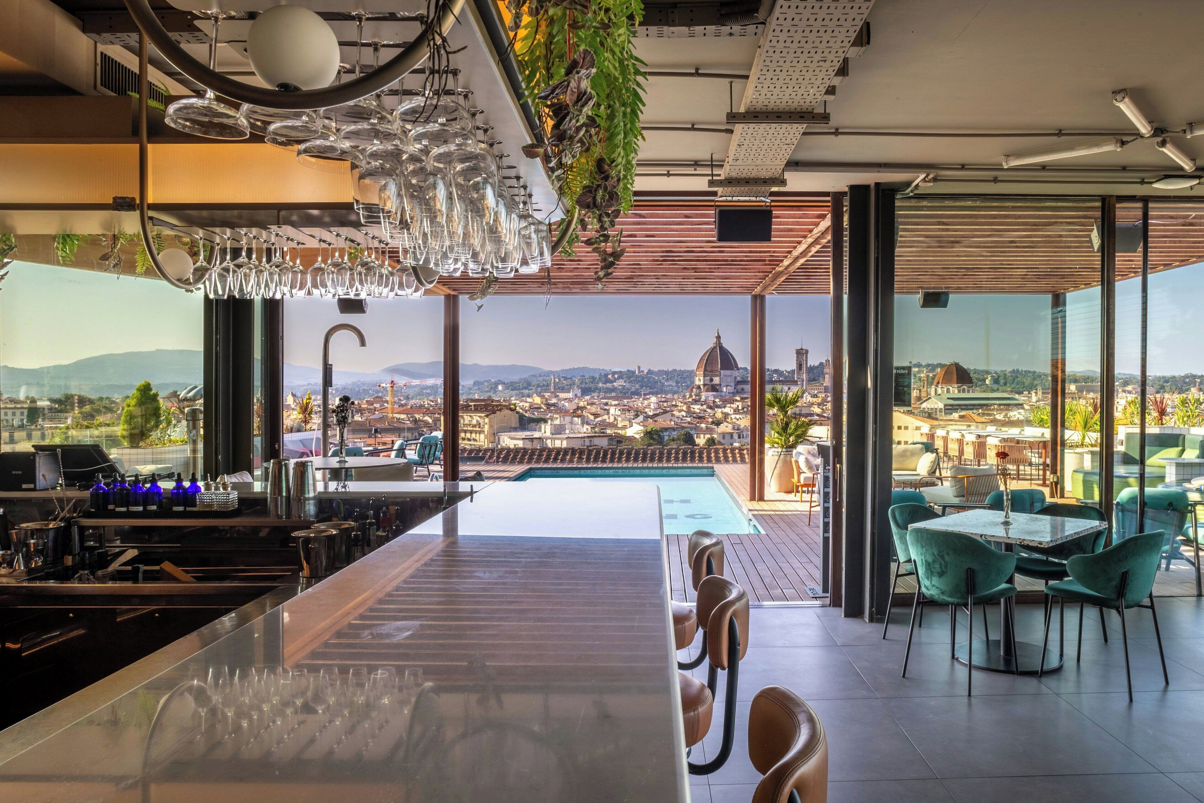 Un'area bar moderna con vista sulla città e su una piscina.