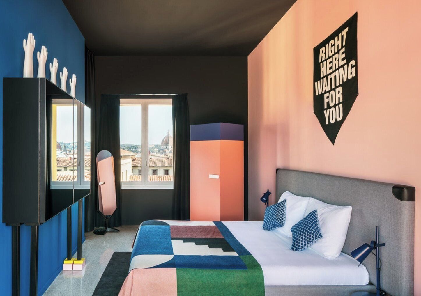 Una camera d'albergo moderna con un letto grande, una scrivania e vista sulla città.