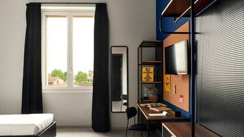 Habitación moderna con cama, escritorio, silla, espejo, televisión y ventana con cortinas.