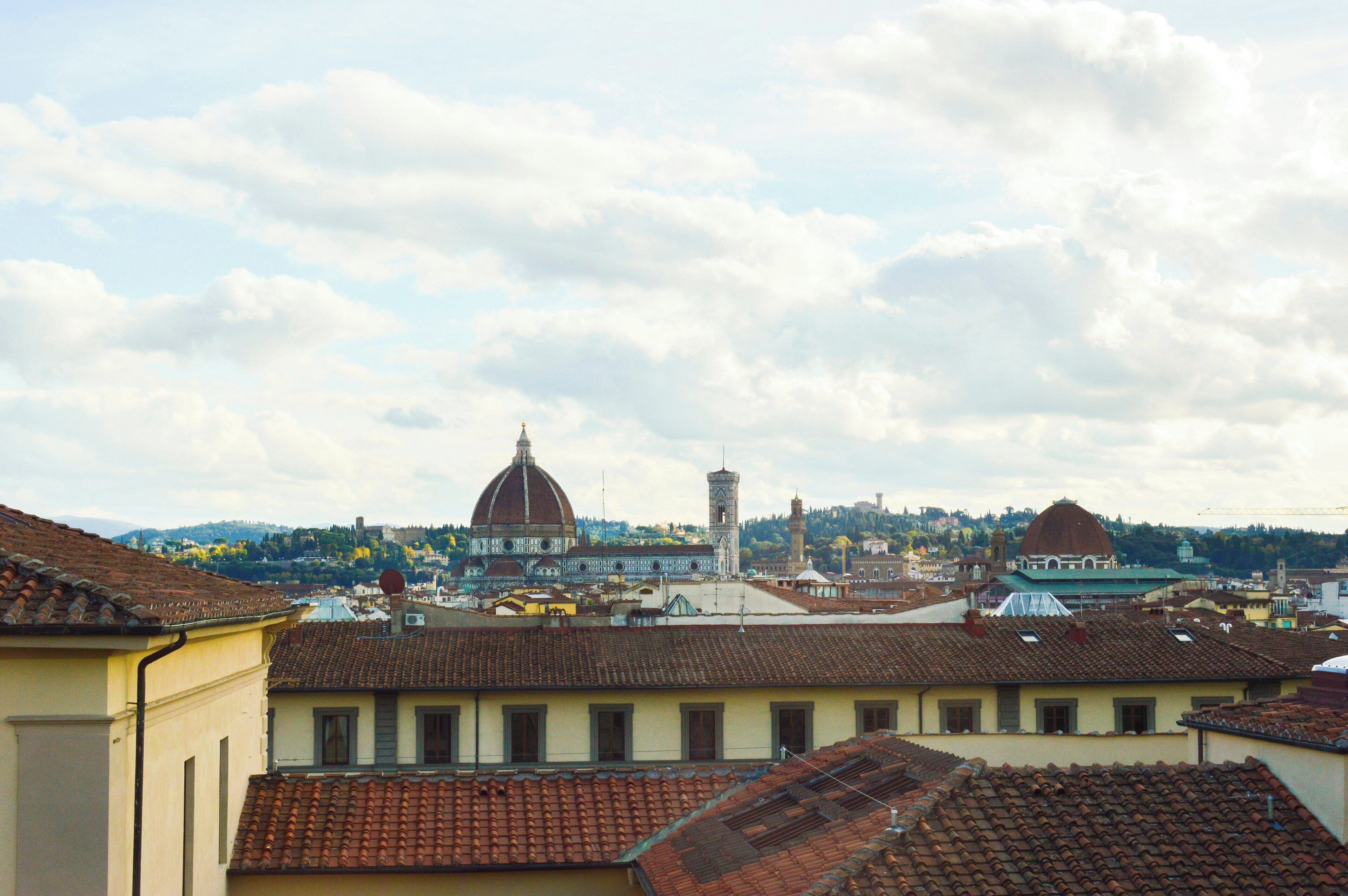 Panorama urbano con edifici storici, una cupola imponente e una torre.