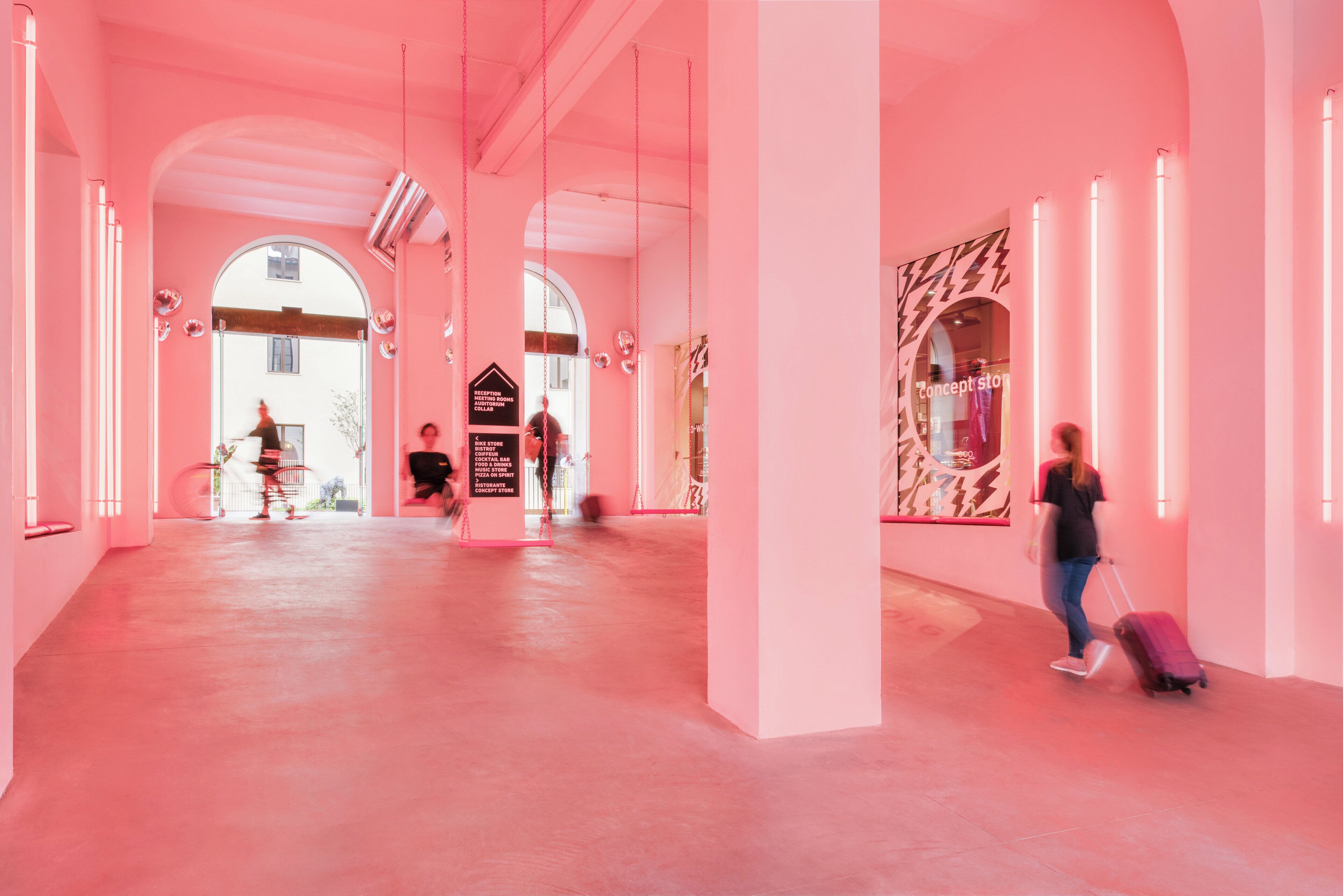 A spacious corridor with arched ceilings and a pink color scheme.