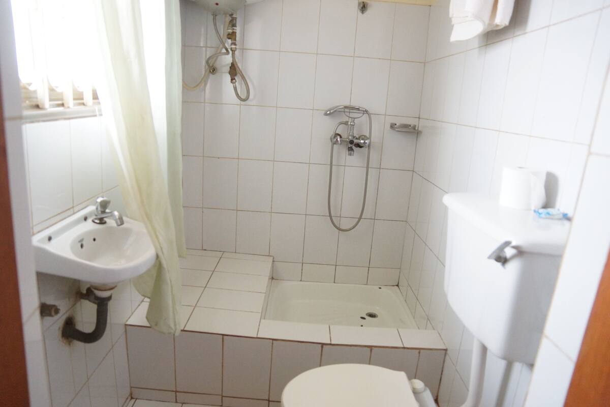 A small bathroom with a sink, toilet, shower, and bathtub.