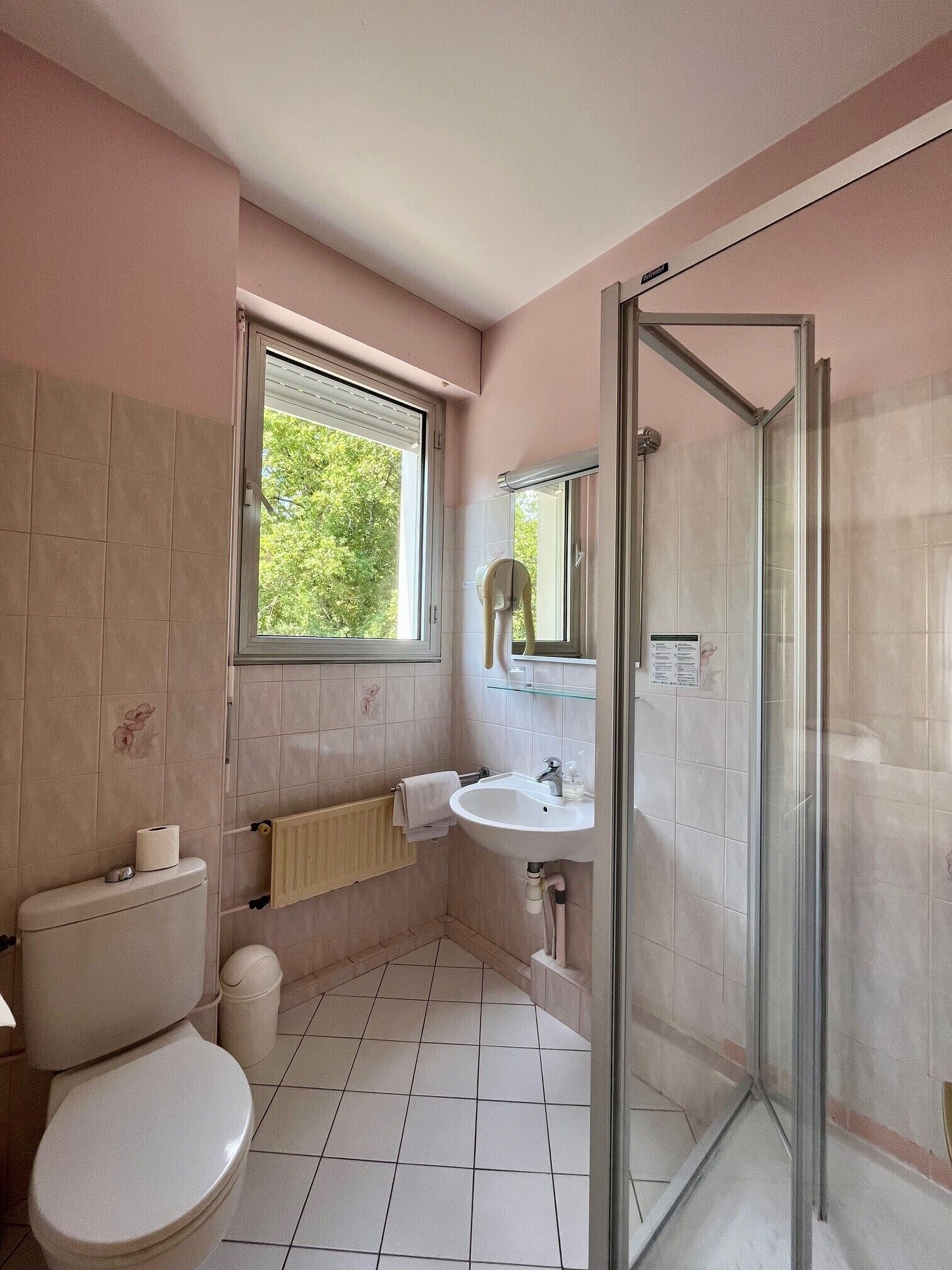 Un baño con inodoro, lavamanos y cabina de ducha de vidrio.