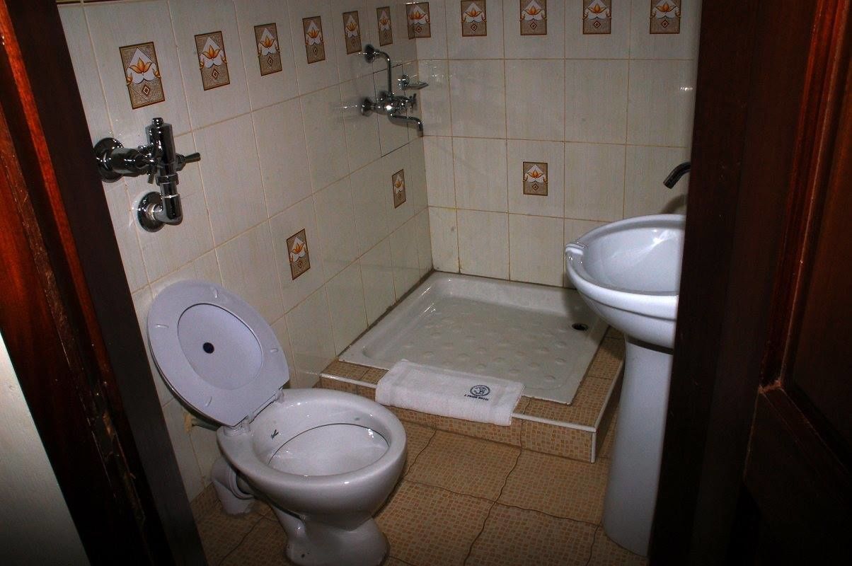 Une petite salle de bain avec des toilettes, un lavabo et une douche.