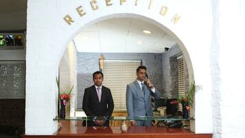 A reception area with a marble wall and a reception desk.