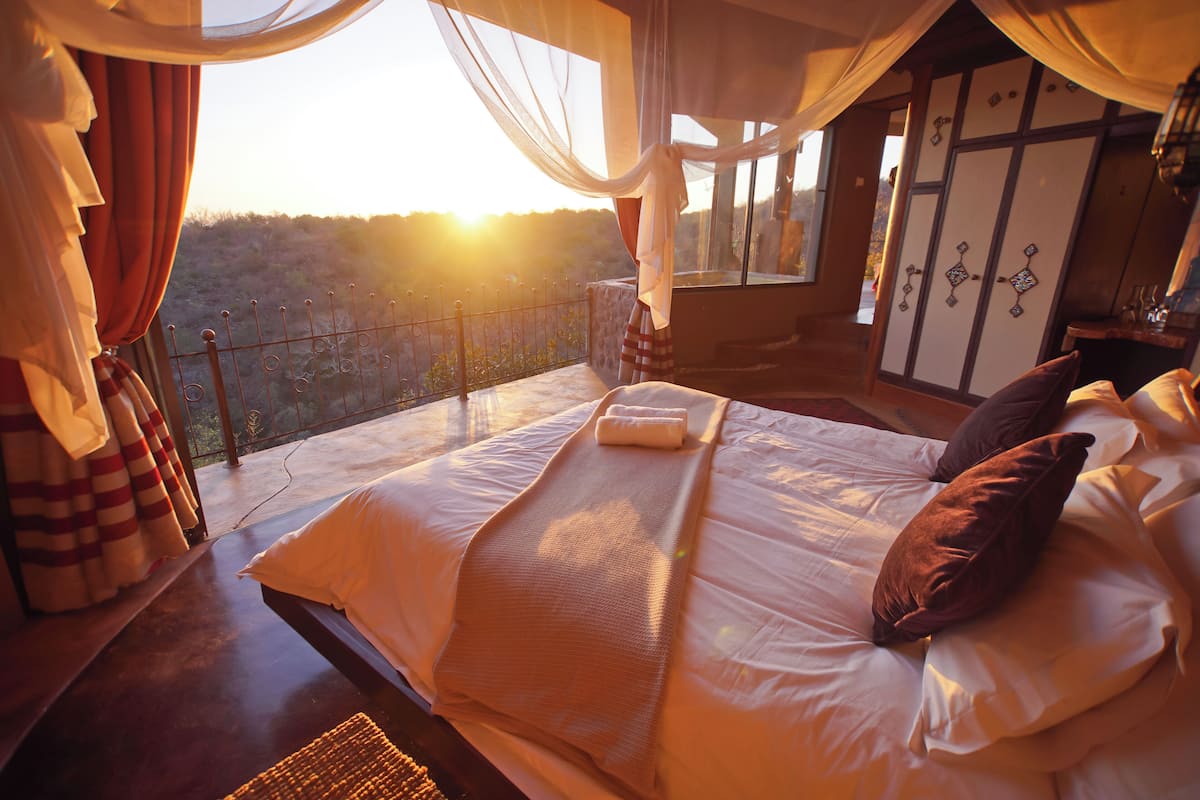 Ein Schlafzimmer mit einem großen Bett, Blick ins Freie und traditioneller japanischer Einrichtung.