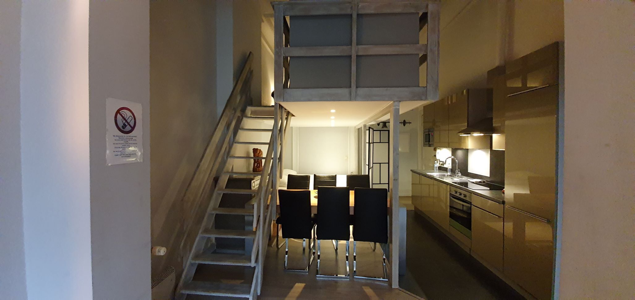 Una escalera estrecha que lleva a una pequeña cocina con comedor.