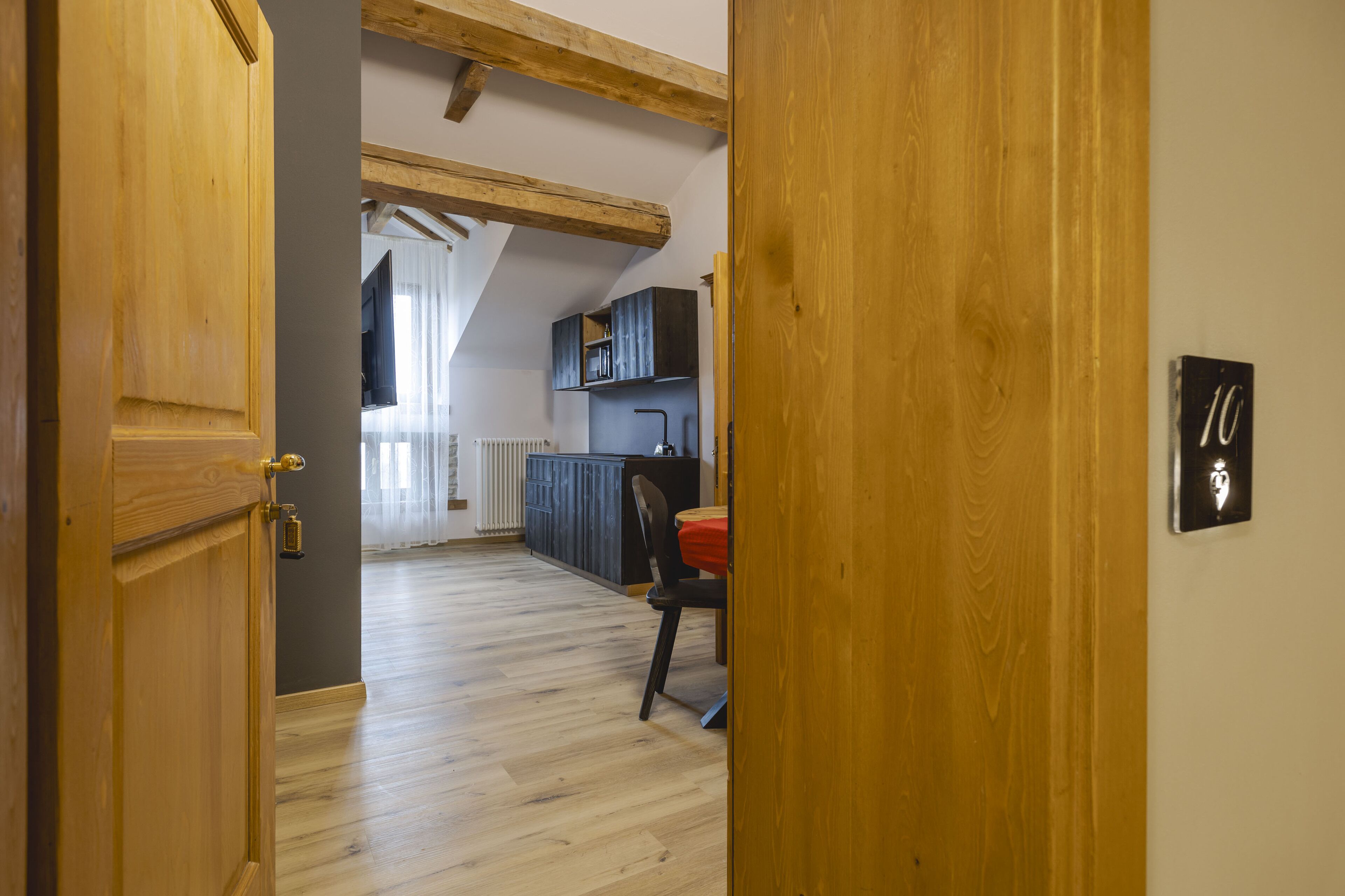 Una puerta de madera que da a una cocina con comedor.
