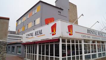 A Hostel Real building with a cafe-bar, restaurant, and restaurant signage.