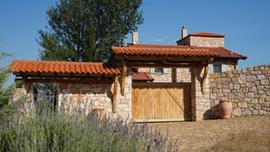 A stone house with a wooden door and a red-tiled roof. - Ariadne Eco Retreat (Polygyros)