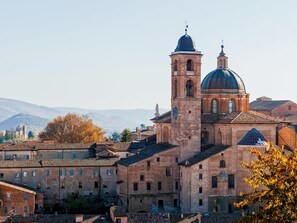 A historic building with a prominent bell tower and a dome, surrounded by traditional architecture. - B&B Villa Paradiso (Urbino)
