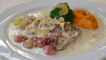 En tallerken mad med cremet sauce, broccoli og en portion kartoffelmos.