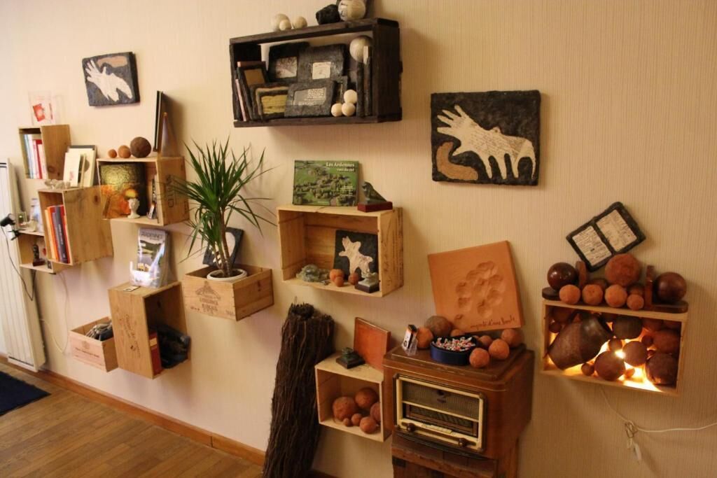 A room with wooden shelves displaying books, decorative items, and a vintage radio.