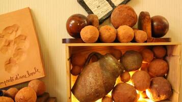 A wooden box filled with round, brown objects and a metal pitcher.