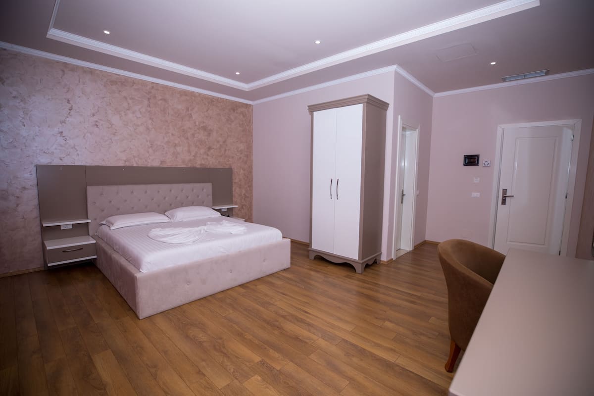 Un dormitorio con cama, armario y silla.