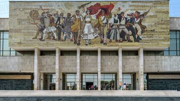 A building facade with a large mural depicting historical figures in uniform.