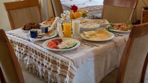 Una mesa de desayuno con diversos alimentos, como huevos, tostadas y fruta.