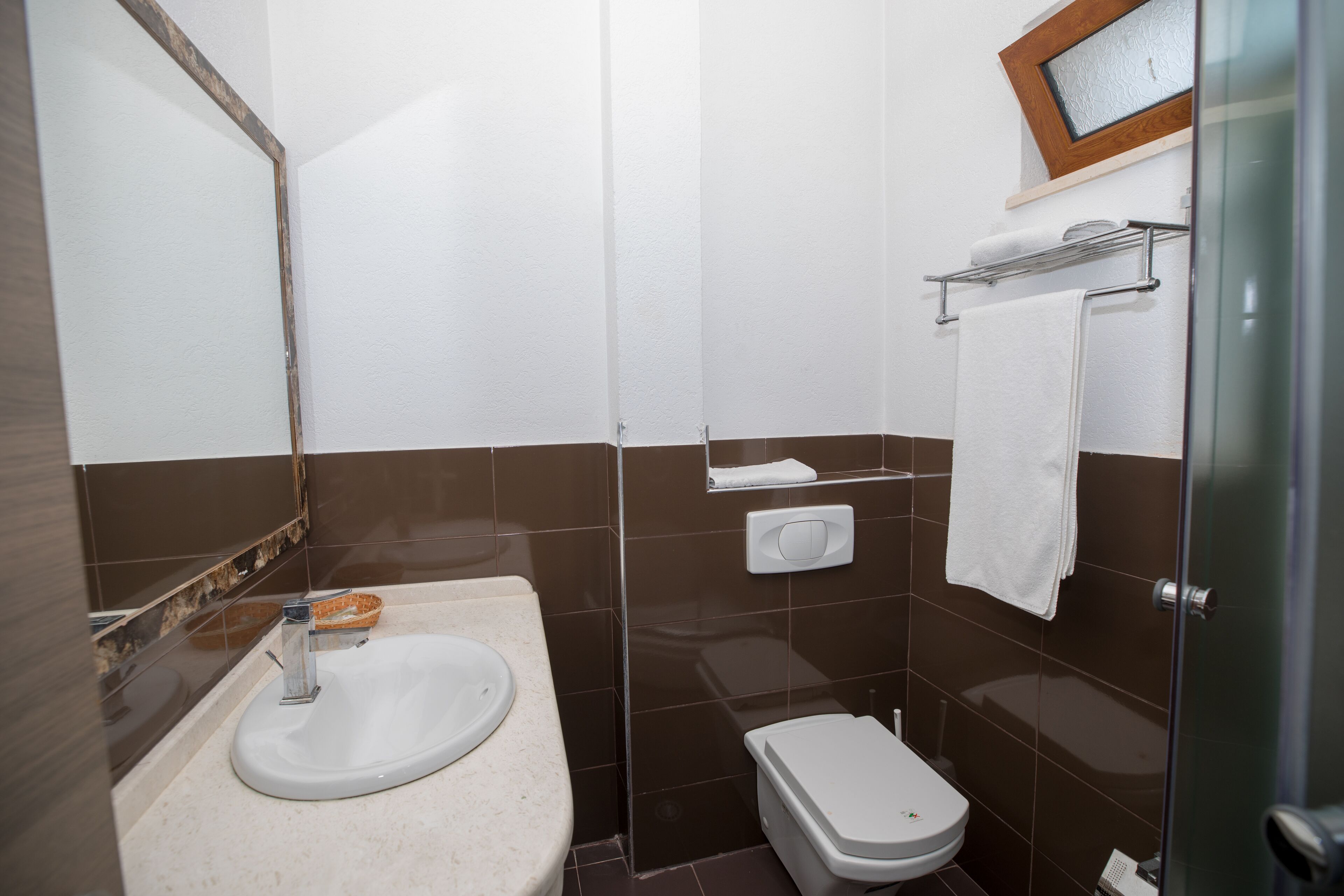 A bathroom with a sink, toilet, and a towel rack.