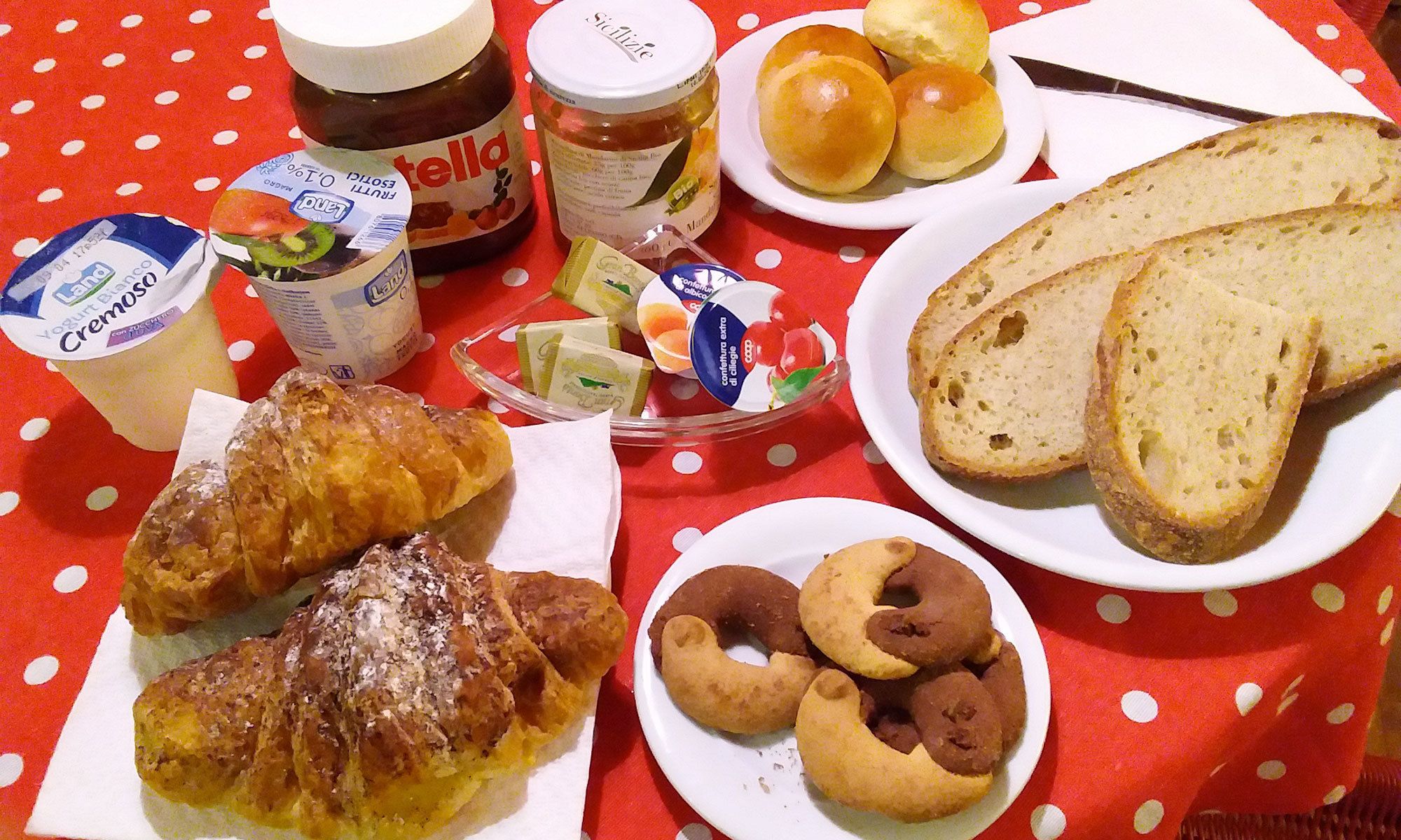 Un tavolo imbandito con pane, pasticcini e salse.