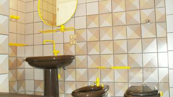 Un bagno con lavandino, WC e specchio.