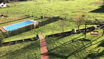 Una piscina al aire libre de temporada, tumbonas
