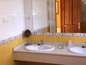 A bathroom with two sinks, a mirror, and a towel rack. - Hotel San Francisco Rural (Parres)