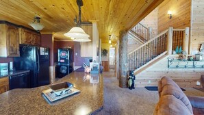 Une cuisine spacieuse dotée de plans de travail en granit, d’armoires en bois et d’un îlot central.