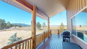 Une terrasse en bois offrant une vue sur un paysage montagneux.