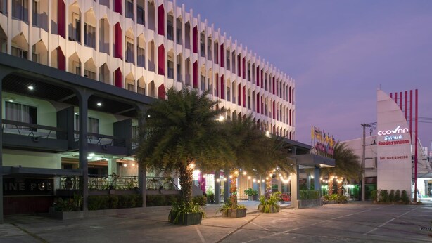 Un hôtel à l’architecture moderne, doté de nombreux balcons et d’un espace extérieur bien éclairé, agrémenté de palmiers.