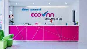 Un comptoir d’accueil aux couleurs vives, notamment un rose éclatant, et arborant le logo « ecovnn ».