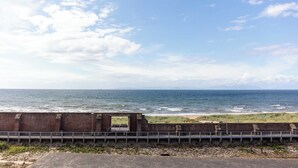 A coastal view with a brick wall and a metal railing overlooking the sea. - Carrick Retreat - Donnini Apartments (Ayr)