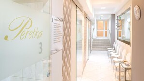 A hallway with a reception area, numbered room 3, and a waiting area with chairs and a reception desk. - Perelka Kolobrzeg (Kolobrzeg)