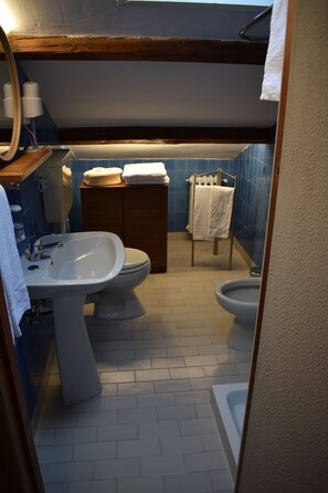 A bathroom with a sink, toilet, bidet, and a towel rack. - Villa Liberty Urbino (Urbino)