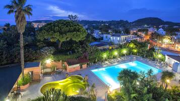 Ein Resort mit Pool, Liegestühlen und einer Palme.