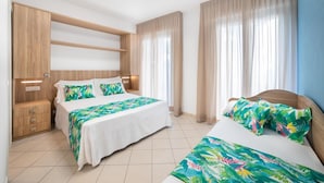 A hotel room with two beds, a wooden wardrobe, and a large window with curtains. - Hotel Amalfi riccione (Riccione)
