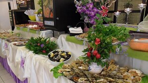 A buffet table with various food items, including oysters, and decorative flowers. - Hotel Amalfi riccione (Riccione)