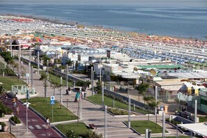 A coastal area with a beach, a marina with boats, and a pedestrian walkway. - Hotel Amalfi riccione (Riccione)