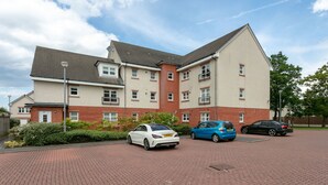 A multi-story residential building with a brick facade and a flat roof. - Elms Way - Donnini Apartments (Ayr)