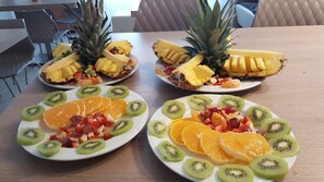 Tres platos de fruta sobre una mesa de madera.