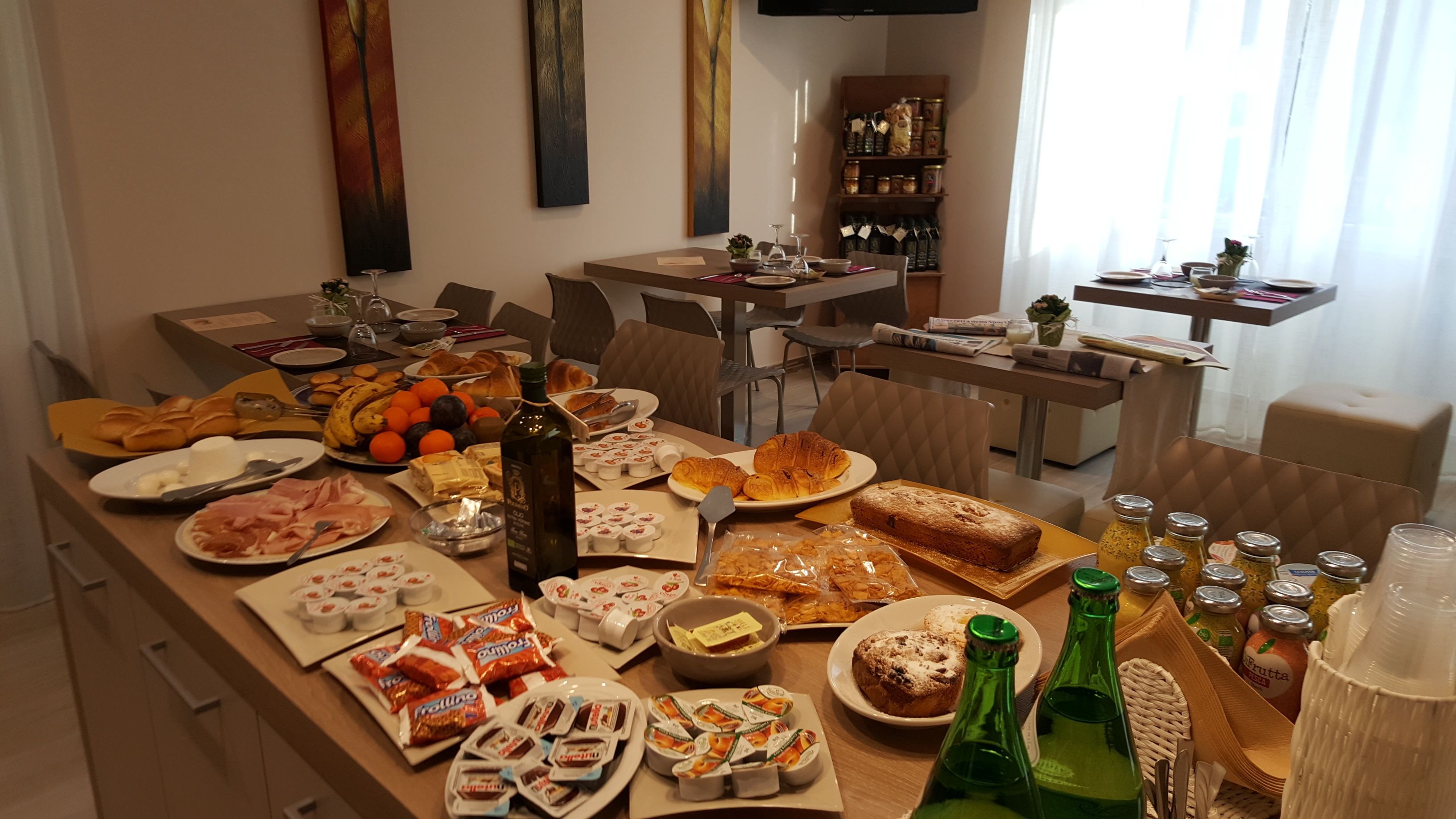Egy jól berendezett étkező, ahol különféle ételek és italok – köztük sütemények, gyümölcsök és köretek – állnak rendelkezésre.