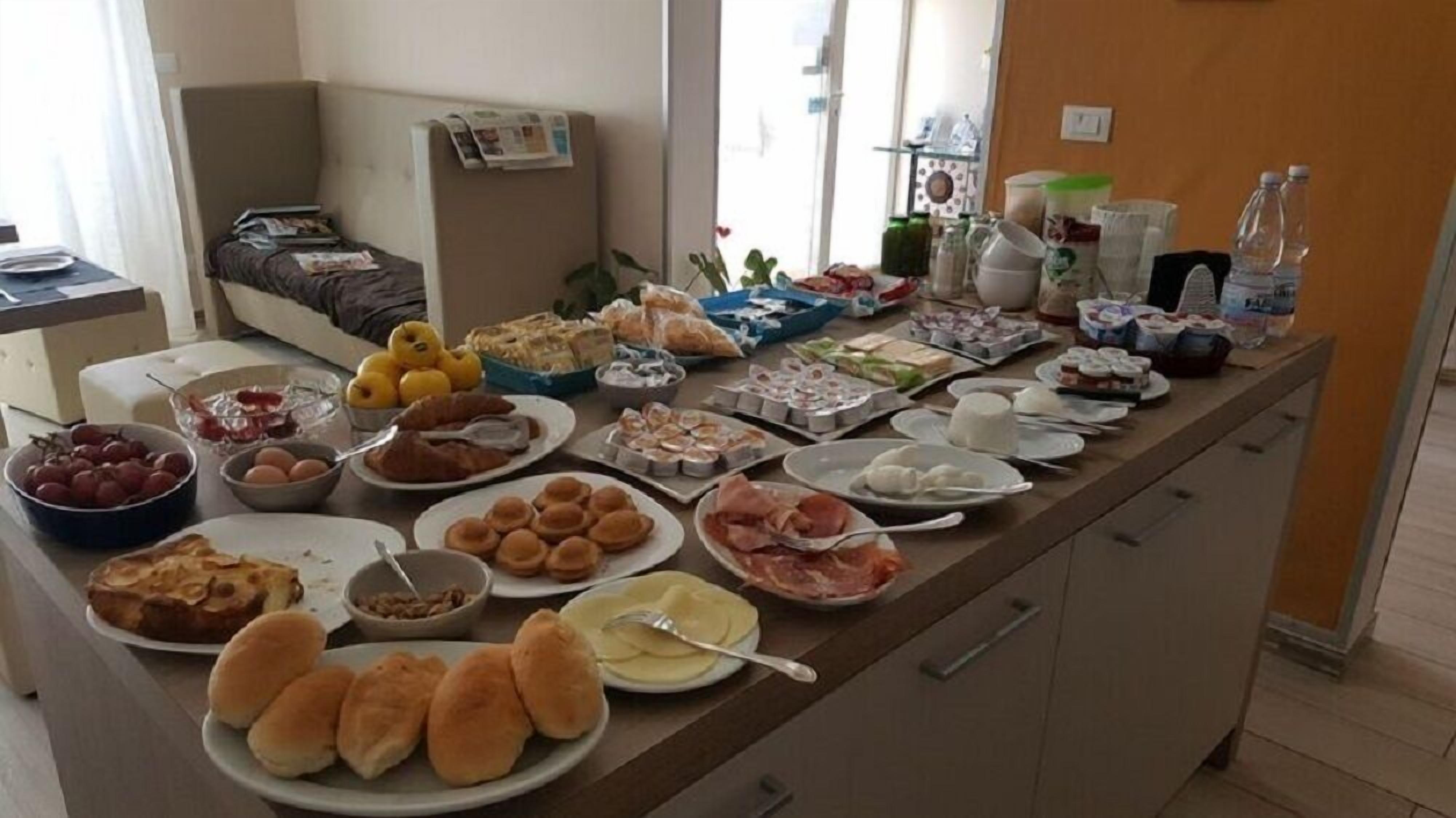 Ein Buffet mit verschiedenen Speisen und ein Bett im Hintergrund.