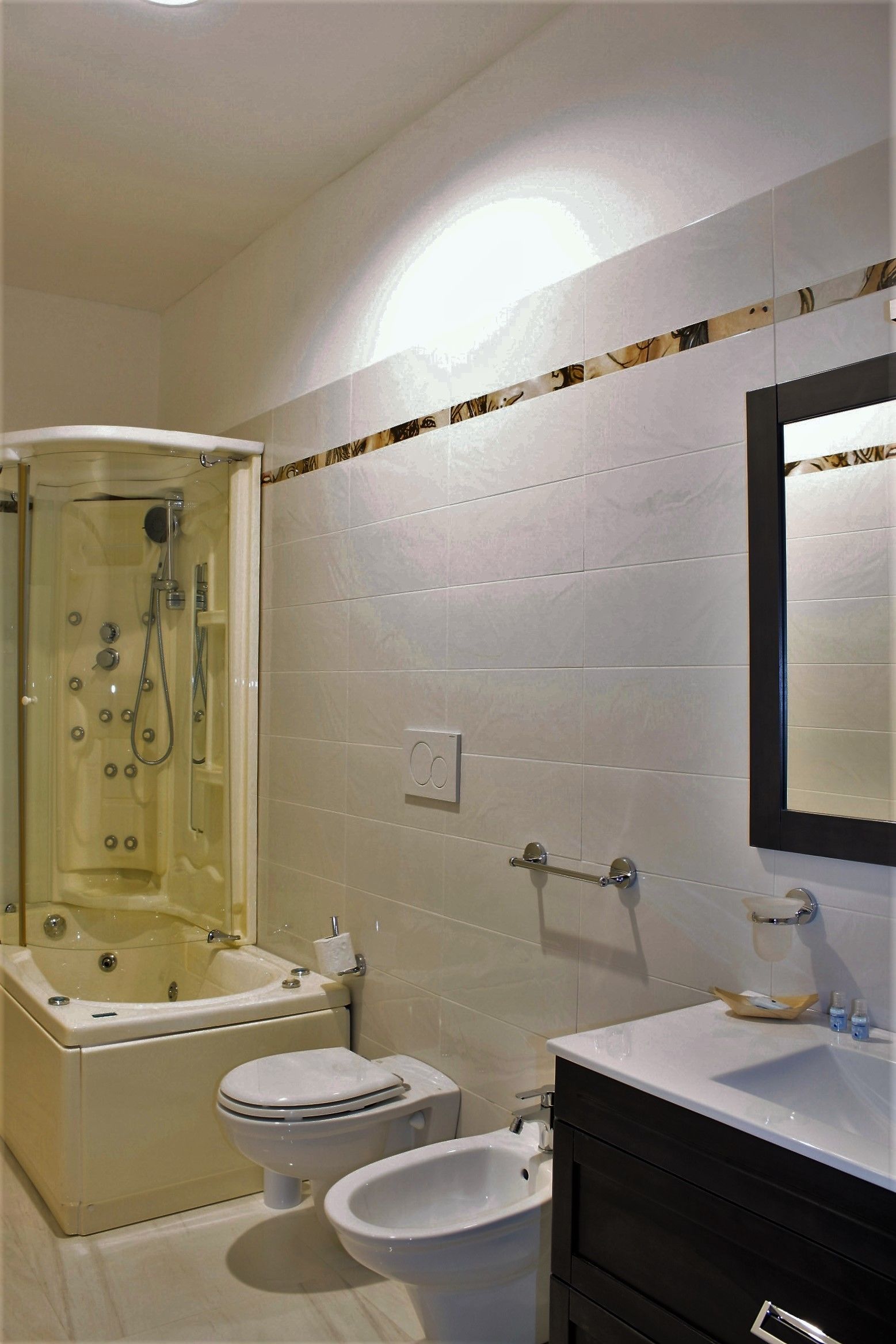 Un baño con bañera, inodoro, bidé y tocador con espejo.