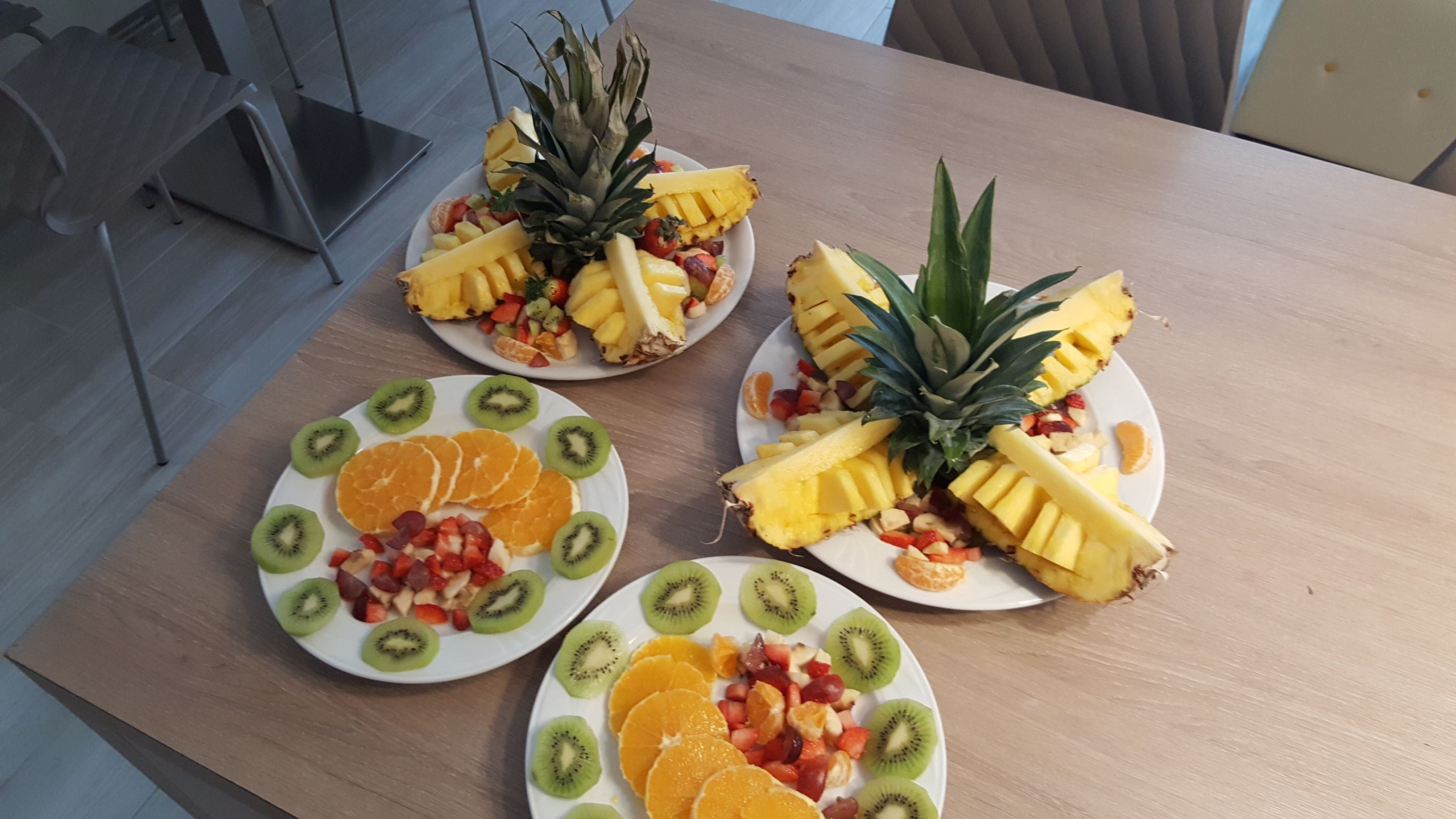 Three plates of fruit on a table.