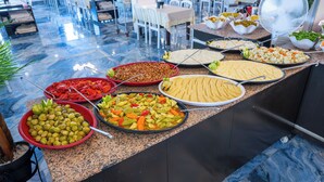 Buffet com diversos pratos, incluindo saladas, legumes e arroz.