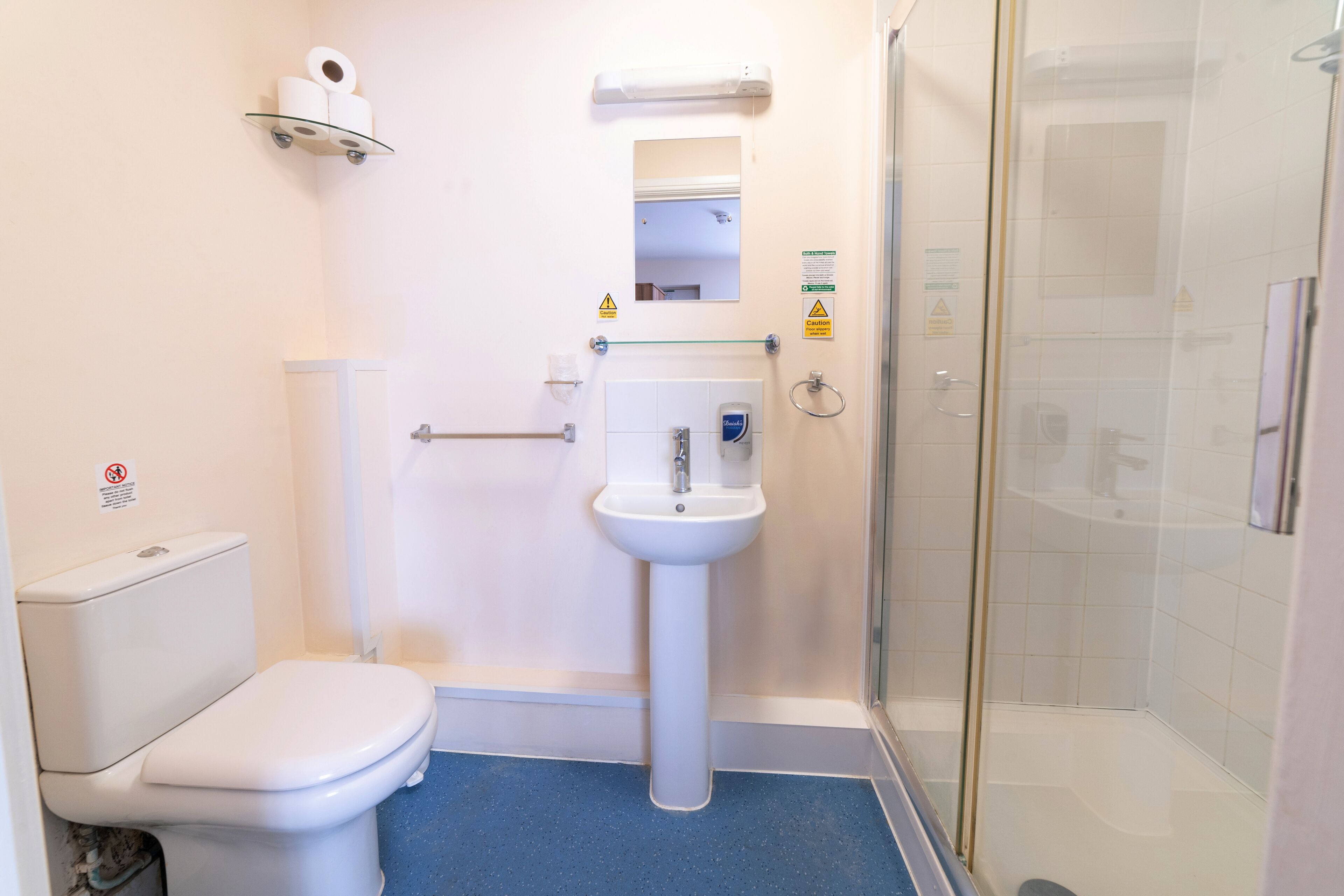 Un baño con inodoro, lavamanos y ducha.